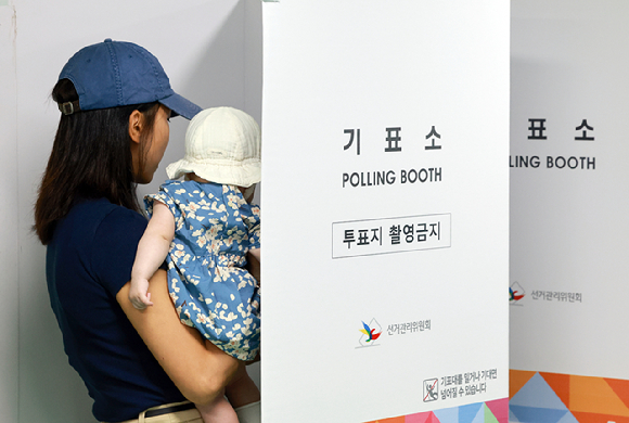 21대 대통령 선거 사전투표 둘째날인 지난달 30일 서울 관악구 낙성대동주민센터에 마련된 낙성대동사전투표소에서 아이를 안은 유권자가 투표하고 있다. [사진=연합뉴스]