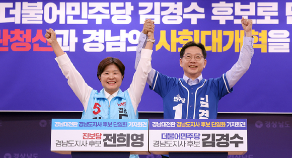 더불어민주당 김경수 경남지사 후보와 진보당 전희영 후보가 27일 오후 경남도청 프레스센터에서 열린 '경남대전환 경남도지사 후보 단일화' 긴급 기자회견에서 손을 들어 인사하고 있다. [사진=연합뉴스]