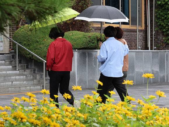 광주 북구청 앞에서 시민들이 내리는 비에 우산을 쓰고 걷고 있다. [사진=연합뉴스]