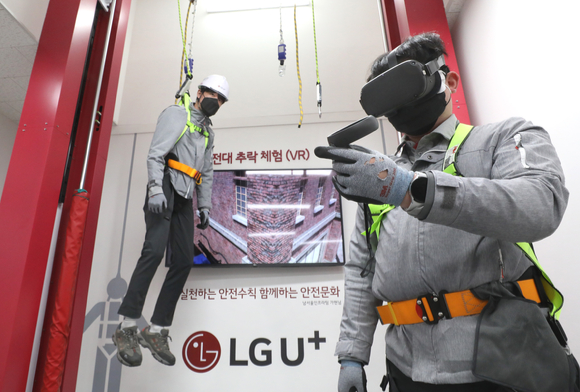 네트워크 안전체험관에서 LG유플러스 소속 교육생들이 안전대를 착용하고 VR로 추락사고를 체험을 하고 있는 모습 [사진=LGU+]