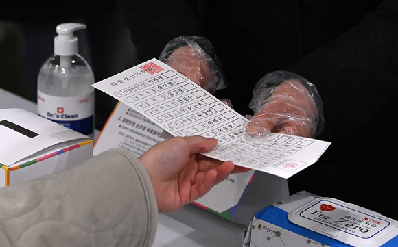 지난 제20대 대통령 선거 당시 한 유권자가 투표용지를 받고 있다. [사진=김성진 기자]