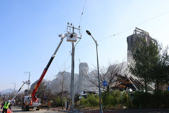 지난 19일 오전 한국전력이 충남 천안시 동남구 이랜드패션 물류센터 화재로 인해 망가진 전선과 전신주를 복구하고 있다. 지난 15일 오전 6시 8분께 물류센터에서 불이 나 60시간 만인 17일 오후 6시 11분께 완전히 진화됐다. [사진=연합뉴스]