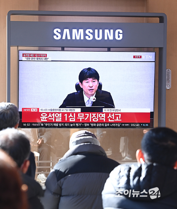 19일 오후 서울역 대합실에 설치된 TV를 통해 윤석열 전 대통령의 내란 우두머리 혐의 1심 선고가 생중계 되고 있다. 이날 재판부는 윤석열 전 대통령에게 무기징역을 선고했다. [사진=곽영래 기자]