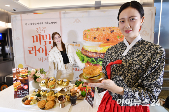 롯데리아가 7일 서울 마포구 롯데리아 홍대점에서 신제품 '전주비빔라이스버거' 출시를 알리며 포즈를 취하고 있다. 이번에 출시된 신제품은 2016년 11월 단종 이후 약 7년만에 새롭게 출시된 라이스버거 라인 제품으로 한국 대표 전통음식 비빔밥을 버거로 재해석한 제품이다. [사진=김성진 기자]
