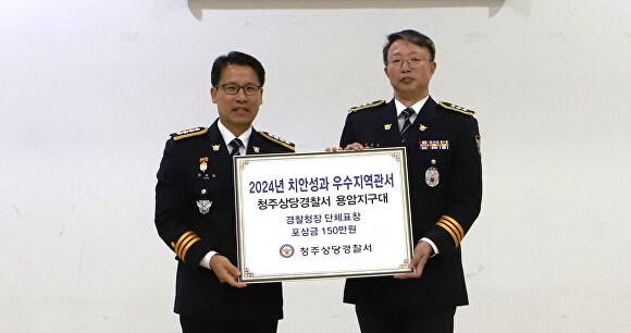 현진호 청주상당경찰서 용암지구대장(오른쪽)이 21일 경찰서 대회의실에서 열린 경찰의날 기념 행사에서 경찰청장 단체표창을 받고 변재철 서장과 기념 촬영을 하고 있다. [사진=청주상당경찰서]