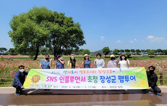 전라남도 장성군에서 주최한 sns 인플루언서 초청 장성군 팸투어에서 인플루언서들이 관련 현수막을 들고 기념촬영을 하고 있다. [사진=장성군]