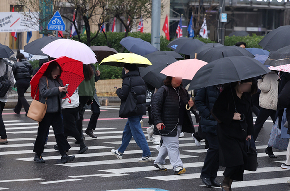 서울 광화문 사거리에서 직장인들이 우산을 쓰고 출근하고 있다. [사진=뉴시스]