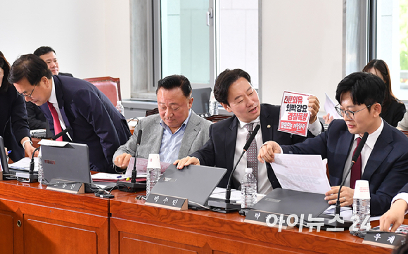 국민의힘 행정안전위원회 의원들이 18일 오전 서울 여의도 국회에서 열린 행정안전위원회 전체회의에서 노트북에 부착한 정원오 더불어민주당 서울시장 후보 관련 피켓을 제거하고 있다. [사진=곽영래 기자]
