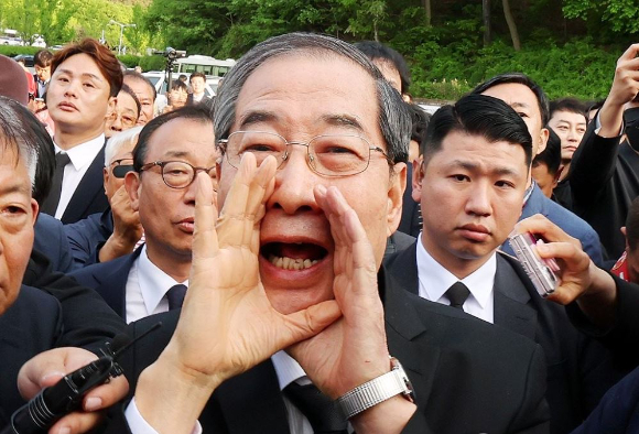 지난해 5월 2일 오후 광주 북구 국립 5&middot;18 민주묘지를 찾은 한덕수 전 총리가 광주비상행동 등 시민&middot;사회단체 관계자들의 반발에 가로 막히자 "저도 호남 사람"이라며 참배를 호소하고 있다. [사진=연합뉴스]