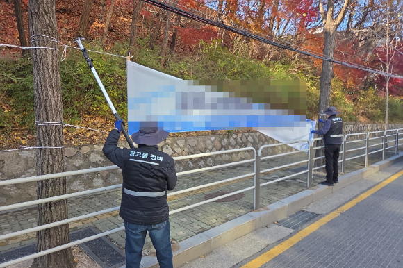 강북구가 혐오·차별 표현을 담은 정당 현수막 등 금지광고물에 대한 정비에 나선다. 사진은 점검반이 불법 현수막을 정비하고 있는 모습. [사진=강북구]
