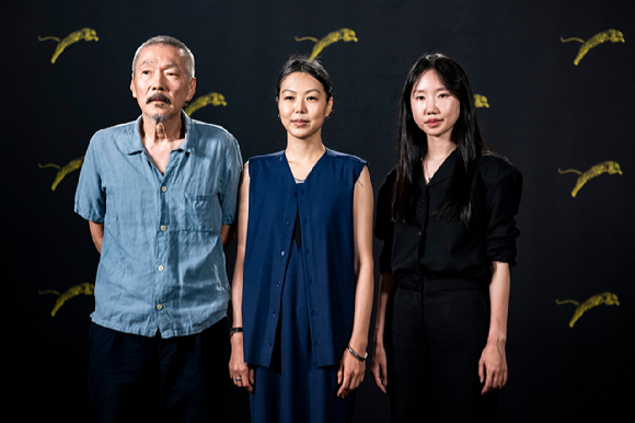 (왼쪽부터) 홍상수 영화감독, 배우 김민희, 박미소가 스위스 로카르노영화제에서 사진을 촬영하고 있다. [사진=EPA/연합뉴스]