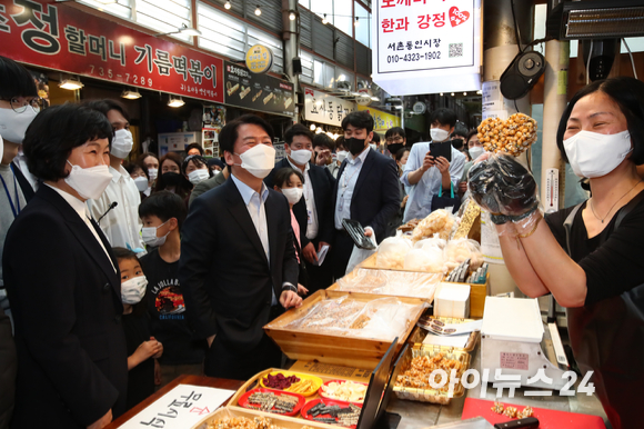 안철수 대통령직 인수위원회 위원장이 10일 서울 종로구 통인시장을 방문해 강정으로 하트모양을 만든 상인과 인사하고 있다. [사진=김성진 기자]