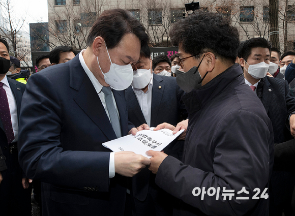 윤석열 국민의힘 대선후보가 15일 서울 영등포구 한국노총에서 열린 간담회에 참석중 한상균 권리찾기유니온 위원장에게 '일하는 사람 누구나 근로기준법' 개정 촉구 입법촉구서를 받고 있다. [사진=국회사진취재단]