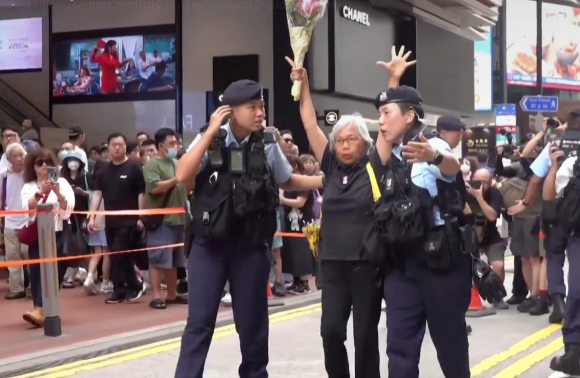 4일 톈안먼 민주화 시위 34주년을 맞은 홍콩에선 경찰의 삼엄한 경비와 함께 체포와 연행이 연이어 이어졌다. 사진은 꽃을 든 한 시민을 경찰이 연행해 가고 있다. [사진=Guardian News 유튜브 캡쳐]